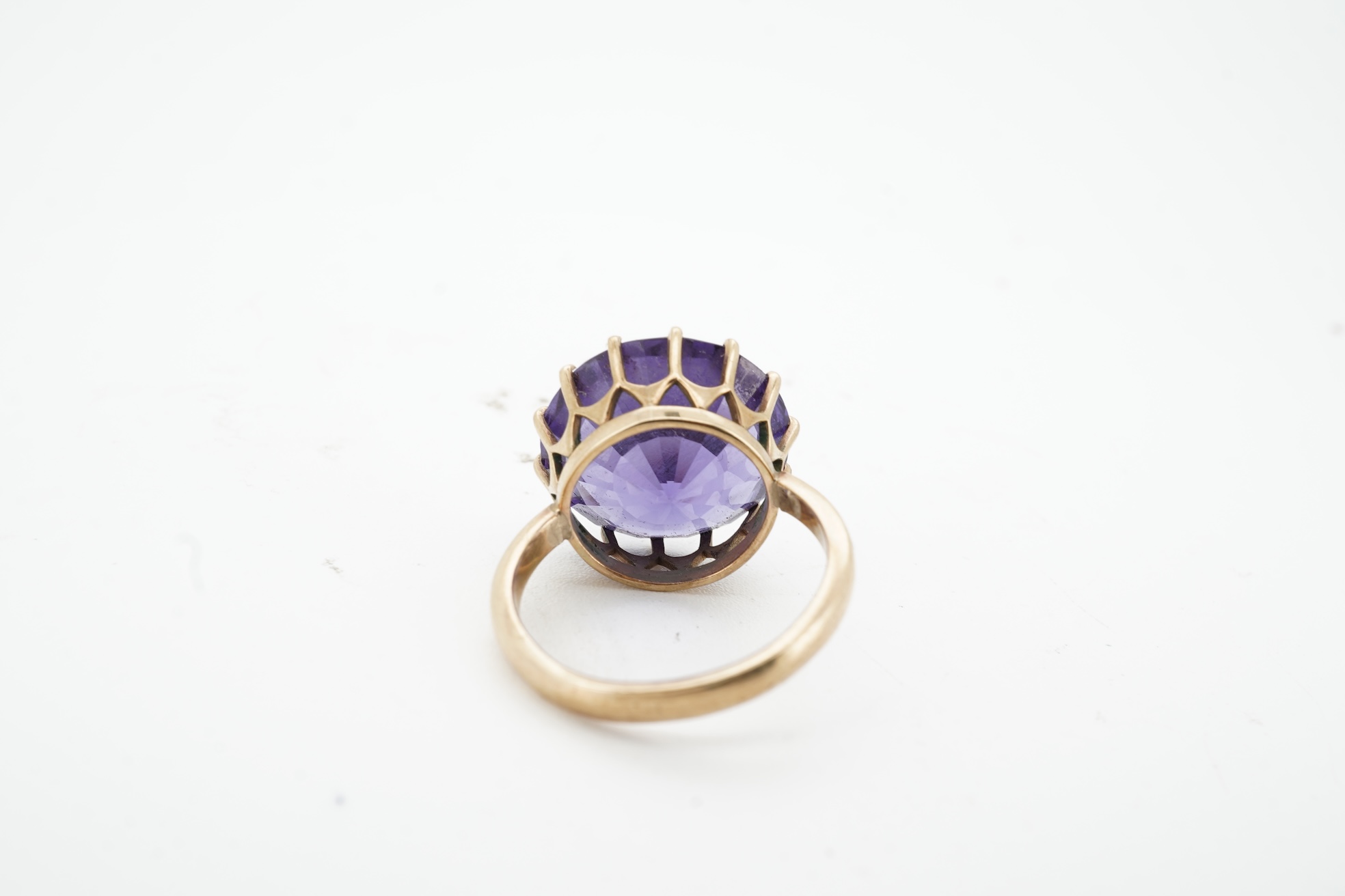 A synthetic colour-change sapphire ring, claw-set with a circular-cut synthetic colour-change sapphire measuring approximately 15 x 15 x 7.9mm, mounted in gold, size H1/2